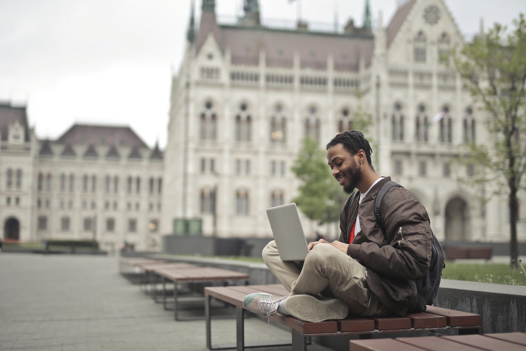 Man_Sitting_On_A_Bench_Using_A_Laptop_original_1562403